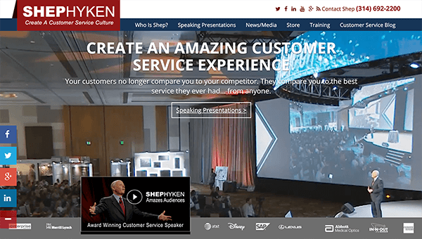 Dies ist ein Screenshot der Website von Shep Hyken. Im Hintergrund spricht er mit einer großen Menge vor einer Projektionswand. Der Website-Text lautet: „Erstellen Sie ein erstaunliches Kundenserviceerlebnis. Ihre Kunden vergleichen Sie nicht mehr mit ihren Mitbewerbern. Sie vergleichen Sie mit dem besten Service, den sie jemals hatten... von irgendjemandem."