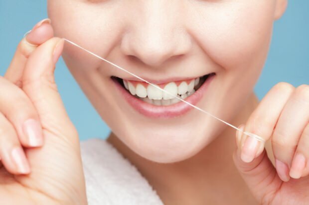 Es wird empfohlen, Zahnseide zu verwenden, um Rückstände zwischen den Zähnen zu entfernen.
