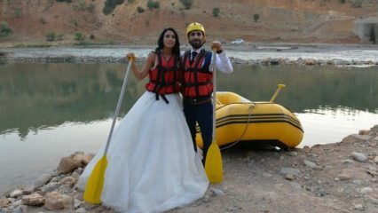 Verrücktes Paar Rafting mit Hochzeitskleid und Bräutigam