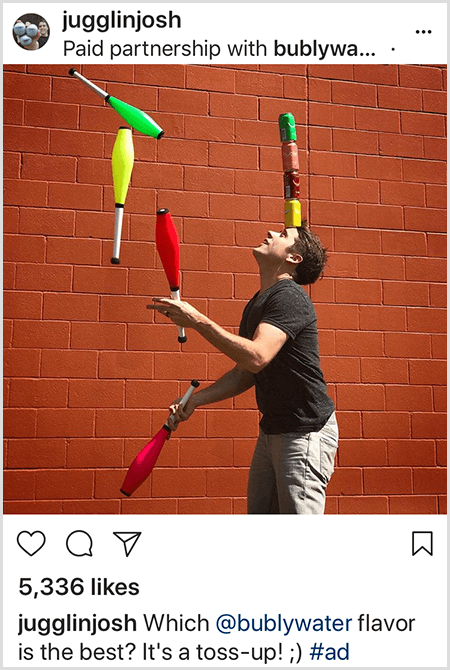 Josh Horton jongliert mit Clubs, die den Farben von vier auf seinem Kopf gestapelten Bubly-Wasserdosen entsprechen. Der Hintergrund ist eine rote Backsteinmauer. Das Foto ist eine Anzeige, die Josh für Bubly Water erstellt und in seinem Instagram-Feed mit der Beschreibung Welcher Bubly Water-Geschmack ist der beste? Es ist ein Toss Up!