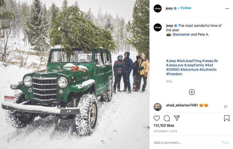 Instagram-Post von @jeep zeigt eine Familie am Ende der Weihnachtsbaumjagd mit einem Baum auf der Spitze ihres Jeeps, tief im Schnee und im Baumland
