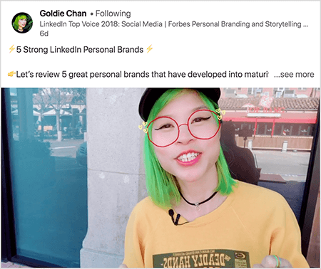 Dies ist ein Screenshot von Goldie Chan, die ein Video mit einem klaren Imbiss teilt. Der Text über dem Video lautet: "5 starke persönliche Marken von LinkedIn Lassen Sie uns 5 großartige persönliche Marken betrachten, die sich zu einer reifen Marke entwickelt haben.". Mehr sehen". Im Videobild erscheint Goldie von der Brust aufwärts. Sie ist eine asiatische Frau mit grünen Haaren. Sie trägt Make-up, eine schwarze Chokerhalskette und ein gelbes Hemd. Ein Videofilter lässt es so aussehen, als würde sie eine rote Brille tragen, die mit einem Marker gezeichnet ist.